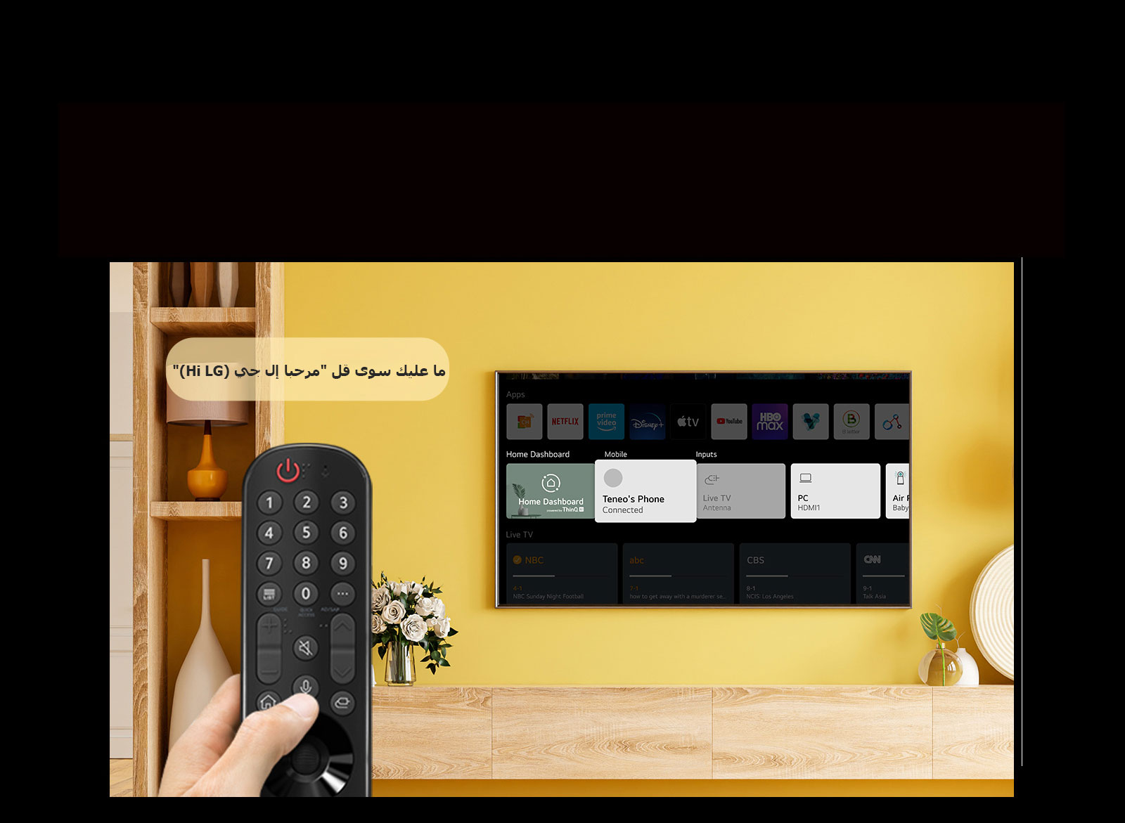 شخص ما يحمل جهاز التحكم عن بُعد الخاص بالتلفزيون أمام شاشة التلفزيون. وتظهر فقاعة حديث بها عبارة "فقط قل مرحبًا إل جي (Just say Hi LG)".