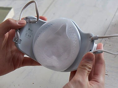 يد تمسك الغطاء الداخلي وتثبته داخل القناع.