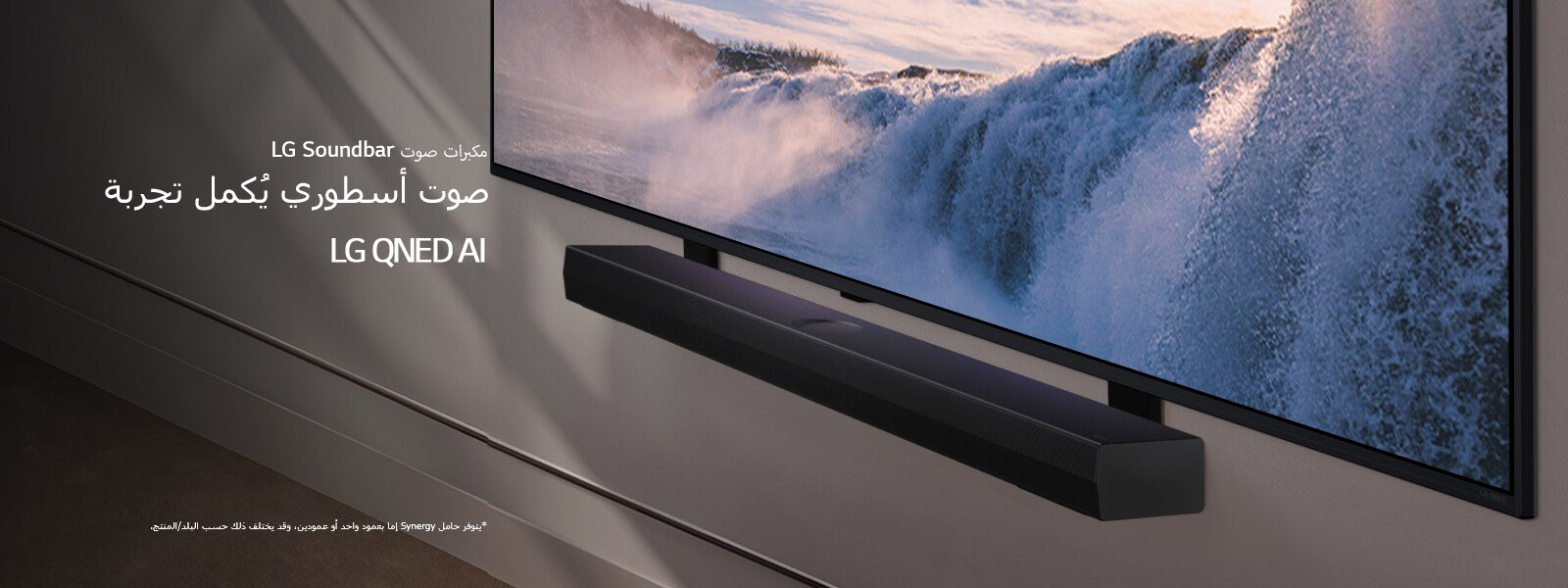 تم تثبيت تلفزيون LG TV، ومكبر الصوت Soundbar على حائط وتصويرهم بمنظور ذي زاوية. يُعرض على شاشة التلفزيون لقطة مُقرَّبة لشلال ضخم، وتتوالى أشعة الشمس الرقيقة على الحائط، والتلفزيون، ومكبر الصوت Soundbar. ينص إخلاء المسؤولية على ما يلي: "يتوفر حامل Synergy إما بعمود واحد أو عمودين، وقد يختلف ذلك حسب البلد/المنتج."