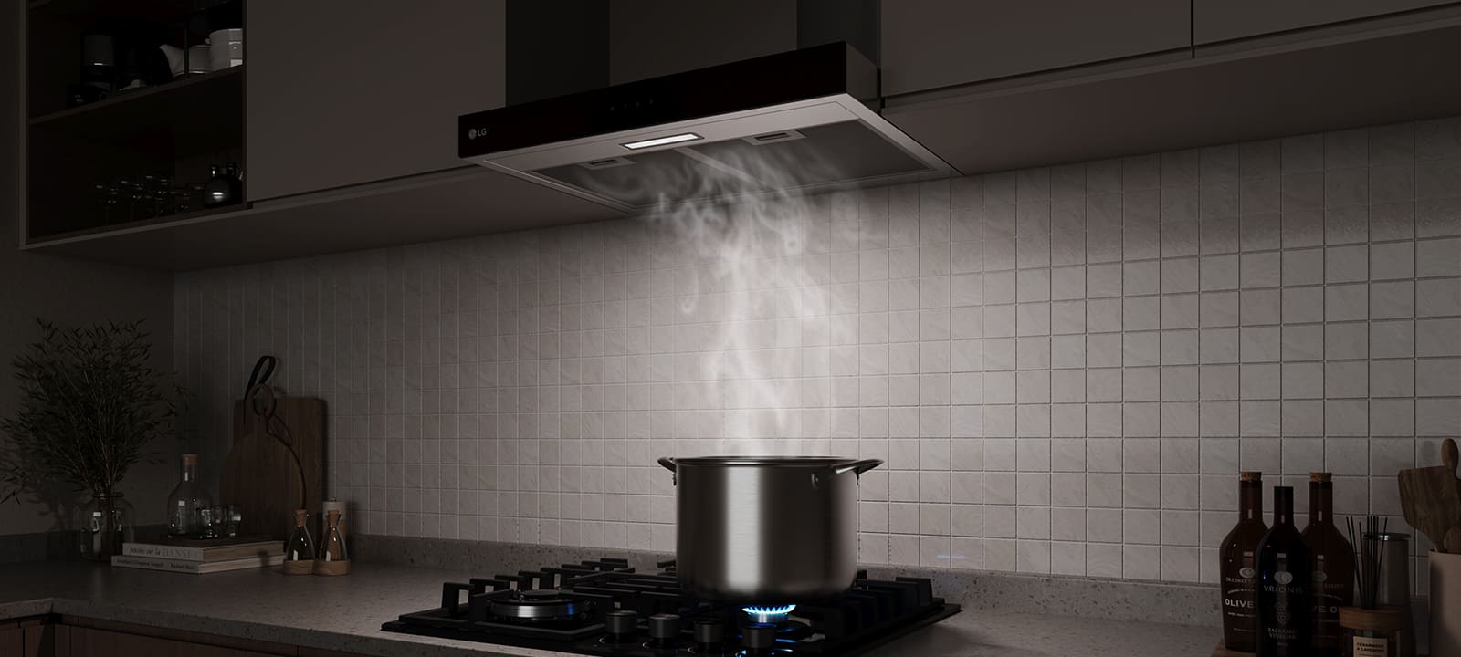 A built-in range hood above a gas cooktop draws in steam rising from a pot while cooking in a modern kitchen.