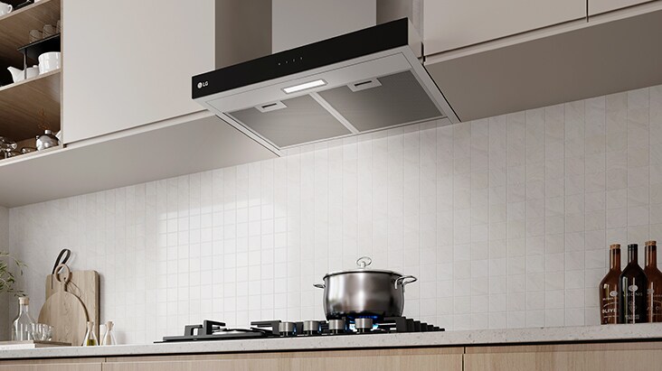 A built-in range hood with LED lighting brightens the gas cooktop and cooking area below.