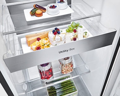 The interior of the fridge shows the drawer labeled "Utility Box". Three arrows push outward indicating the drawer can be pulled out to access the food inside.