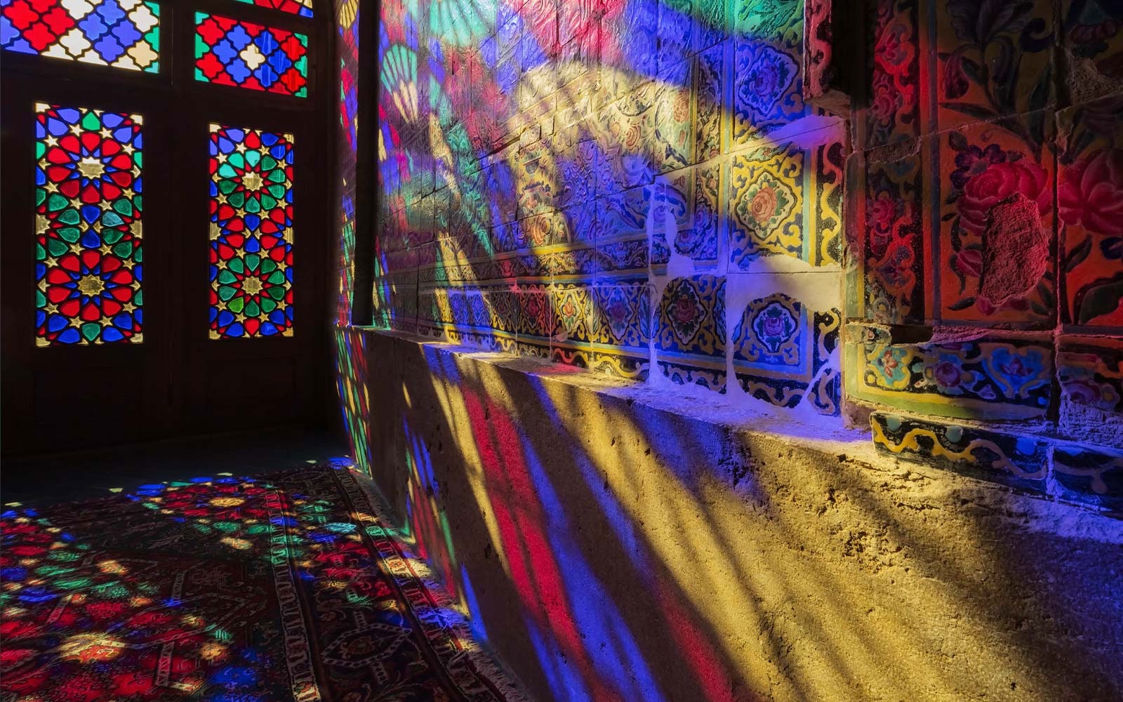 A scene showing light shining through stained glass windows to project colors onto a wall (play the video).