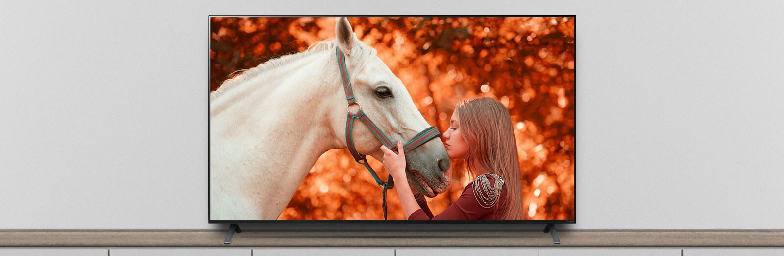 The TV is on the stand, and the screen shows a scene of a movie featuring a horse and a woman.