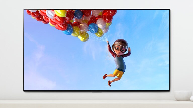 A scene of an animation showing a child hanging from colorful balloons in the sky shown on a TV screen