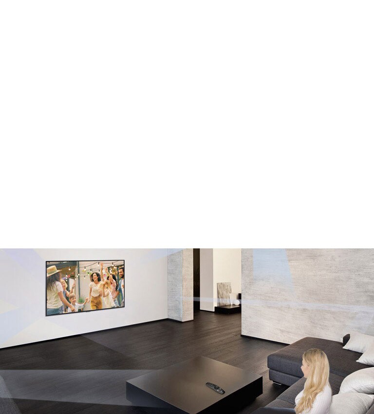 Woman in large and minimalistic living room watching people dancing on TV