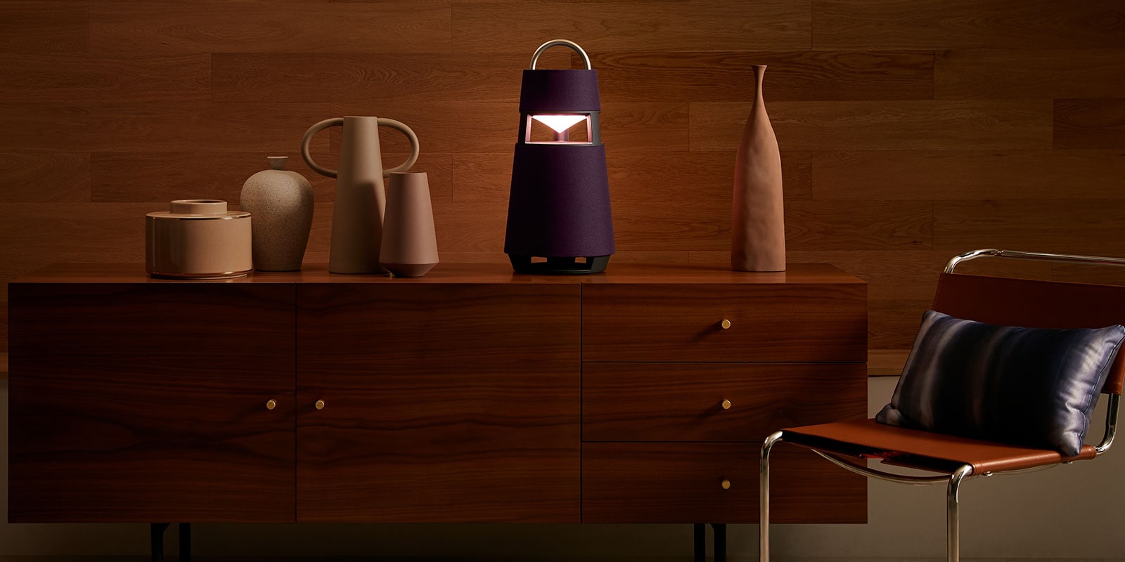 Image of the XBOOM 360 with sculptures on a shelf in a wood-toned interior background.