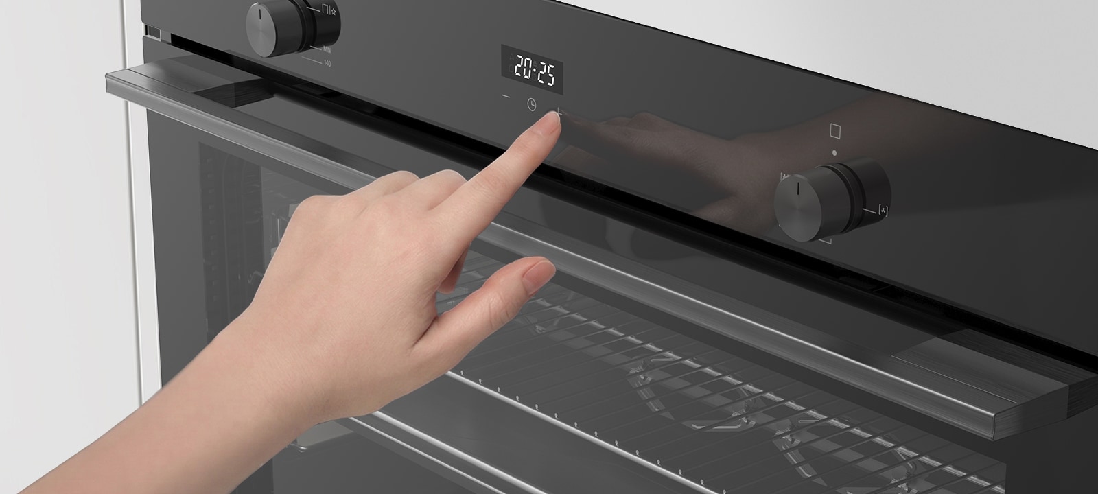 Hand adjusting touch controls on a built-in oven control panel.