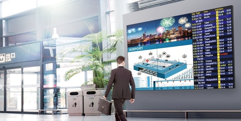 A man passes by while watching the screen and the screen displays vivid color from any angle.