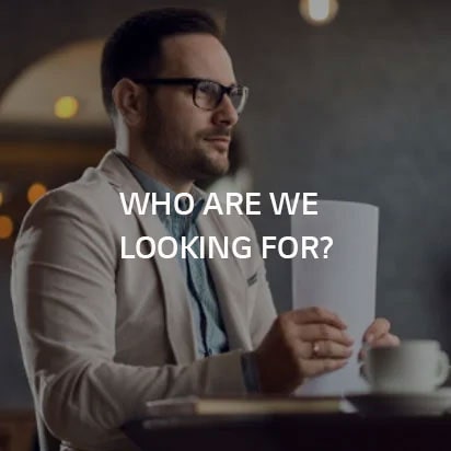  A man sitting at a desk holding a stack of paper