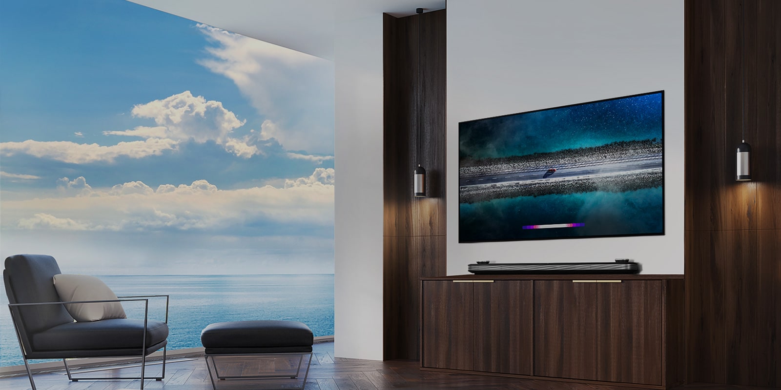 LG SIGNATURE OLED TV W9 is hung on the wall and a counch is laid right in front of tv with the blue sky over the window.			