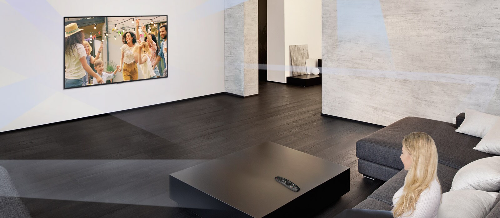 Woman in large and minimalistic living room watching people dancing on TV