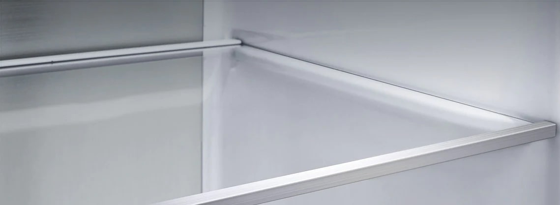 A diagonal view of the shelf with metallic paneling on the interior of the refrigerator.