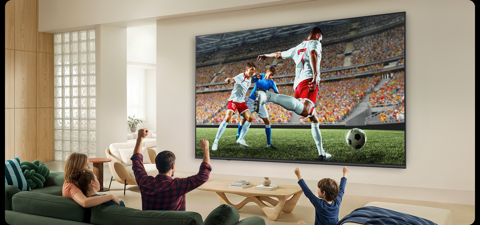 LG QNED evo AI Mini LED QNED82 Ultra Big TV shows an intense, large-scale soccer play with refined picture quality and vivid colors as a family cheers together from sofas in a living room.