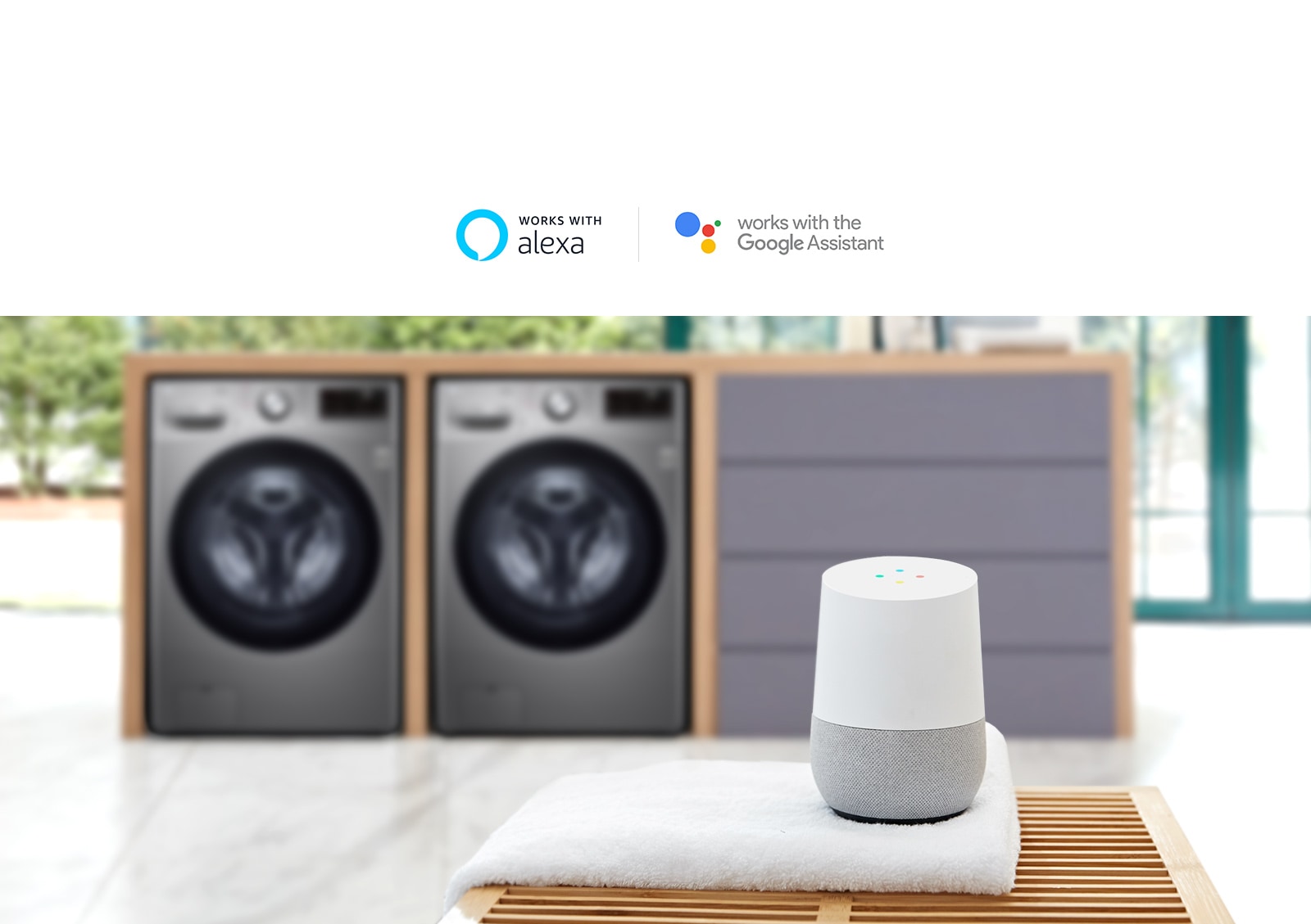 Background of the image is two washing machine with the LG ThinQ sitting on a towel on a table in the foreground.