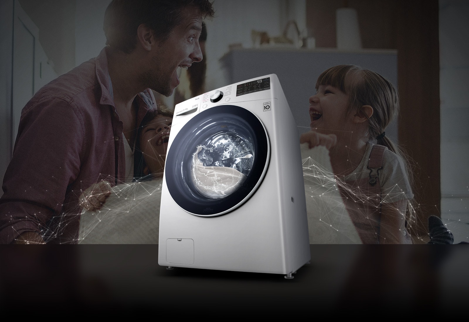 Father and daughters laugh in the background. A White washing machine front load washer in the foreground.