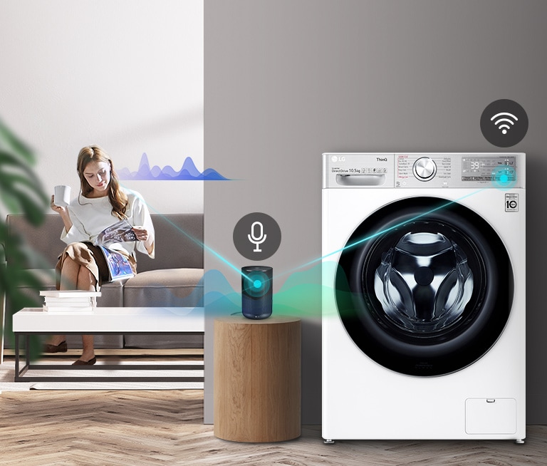 A woman sitting on the couch and drinking tea is giving orders to her washing machine through her AI speaker.