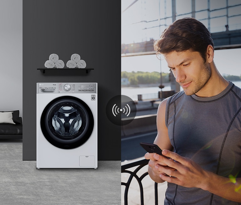 A man outdoors is checking the condition of a washing machine at home through a mobile phone app.