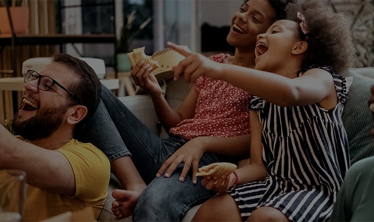 A group of friends gather in a huddle laughing.