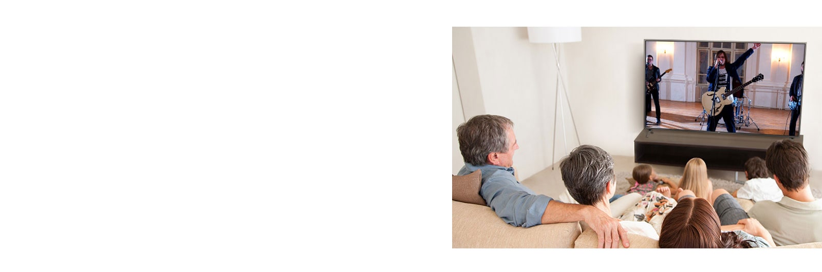 Family of seven gathered in the living room,  watching a movie. TV screen shows a band performing.