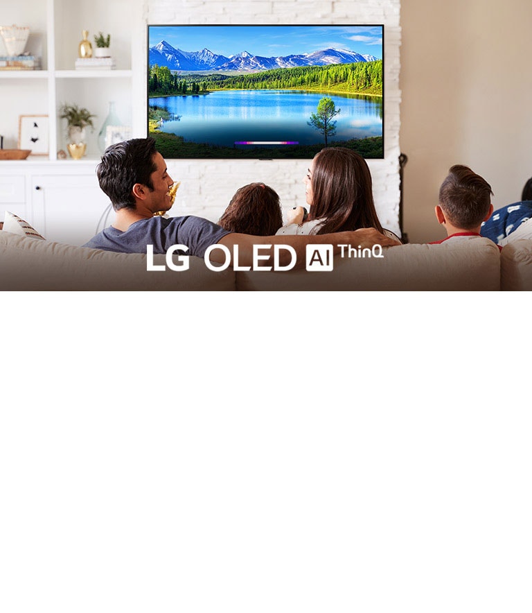 Family in bright living room looking at landscape on wall-mounted TV