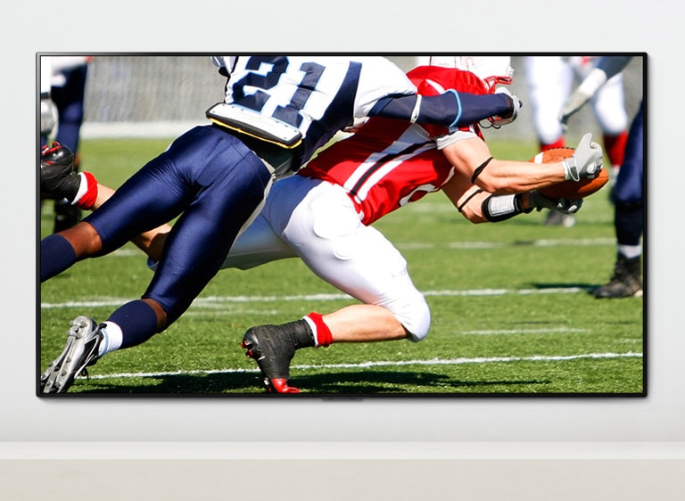 A scene of a sports game showing two men who are playing dynamically playing American football on a TV screen A scene of a sports game showing two men who are playing dynamically playing American football on a TV screen Sports