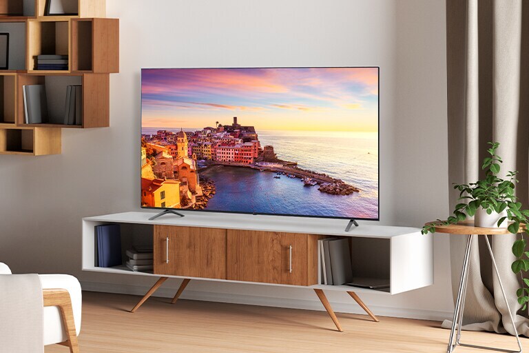 A TV is hanging on the wall of the hotel room, and the TV screen is bright and clear.