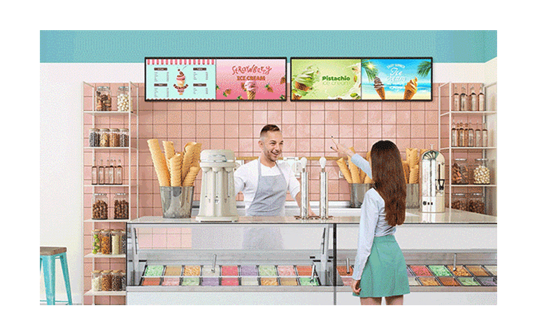 Inside an ice cream shop, there is a BH7N installed, and the screen is simultaneously showing the ice cream menu and advertisements.