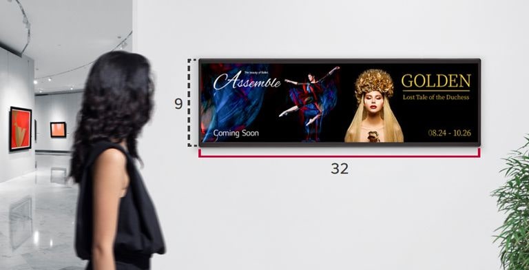 A woman is watching a performance advertisement on a wide screen with a 32:9 aspect ratio.