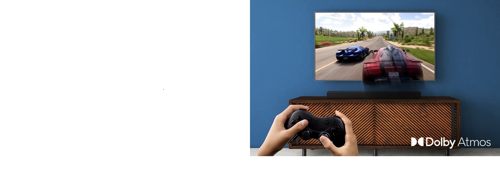  LG TV is on the wall, showing a racing game. LG Sound Bar is place on the brown shelf, right below LG TV. A man is holding a joy stick.