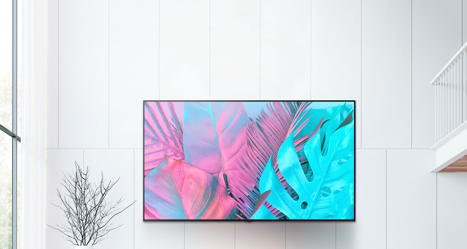 A large flatscreen TV mounted against a white wall. The screen shows large leaves in bright colors.