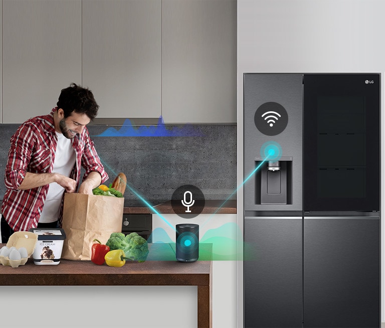 A man stands in a kitchen unloading produce from a grocery bag and speaks, shown by volume bars moving up and down near him, to the AI speaker on the counter telling it to "turn on express freeze". A line appears that goes from the man to the AI speaker which has a microphone icon above it. Then volume bars show up near the AI speaker and a line appears from the AI speaker to the refrigerator which has a Wifi icon above it.