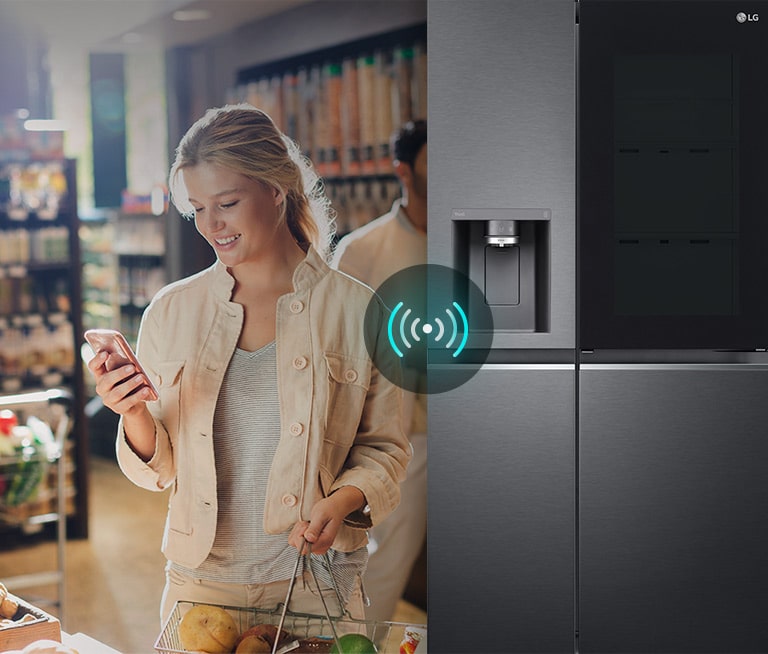 Image on the left shows a woman standing in a grocery store looking at her phone. Image on the right shows the refrigerator front view. In the center of the images is an icon to show connectivity between the phone and refrigerator.