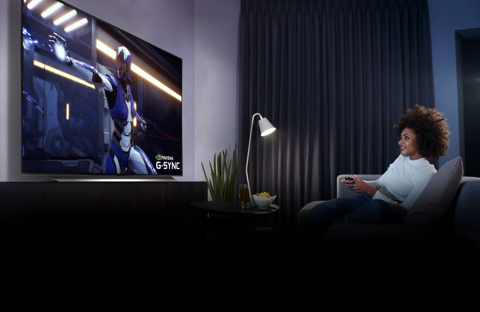 A TV with a scene of game character and a PC on a desk