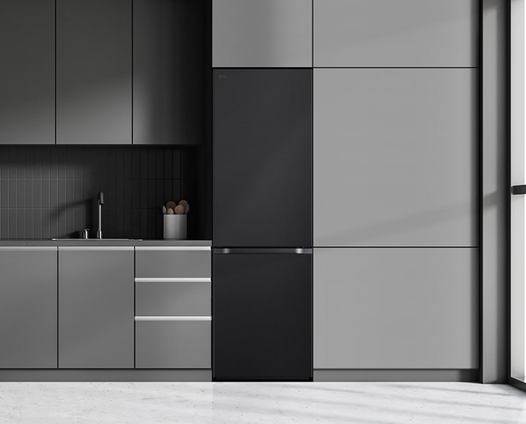 Moderni virtuvė su šaldytuvu, kuris sklandžiai įsilieja į šalia esančias spinteles ir primena įmontuotą modelį.