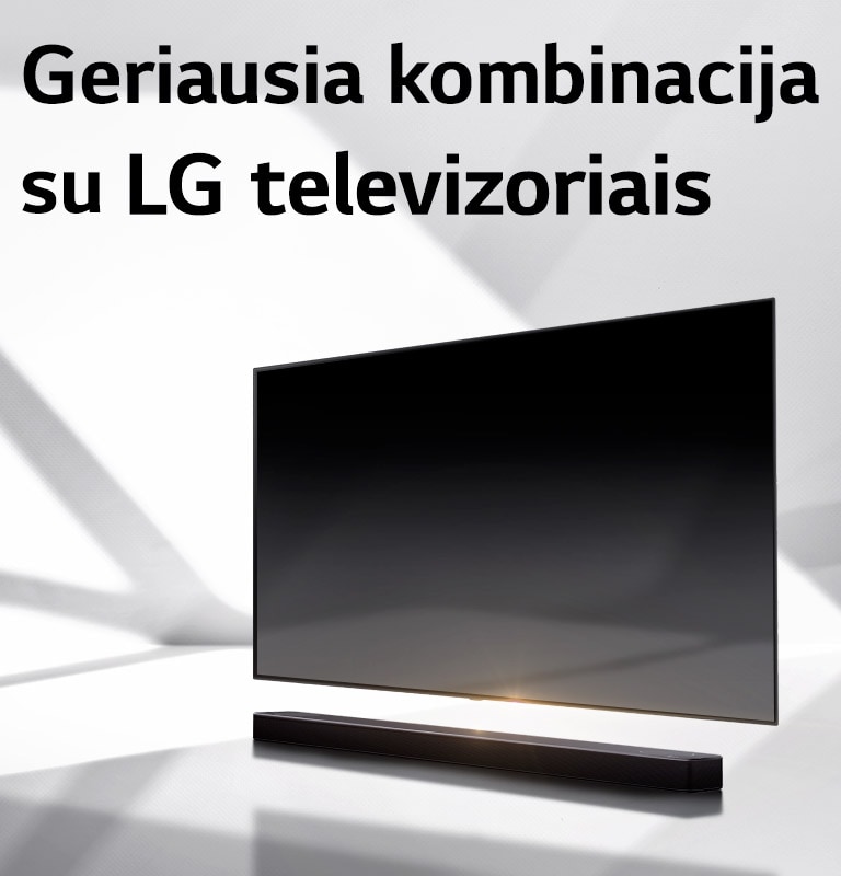 Horizontalusis garsiakalbis ir televizorius pastatyti ant baltų grindų, o už jų krenta šešėlis iš lauko.