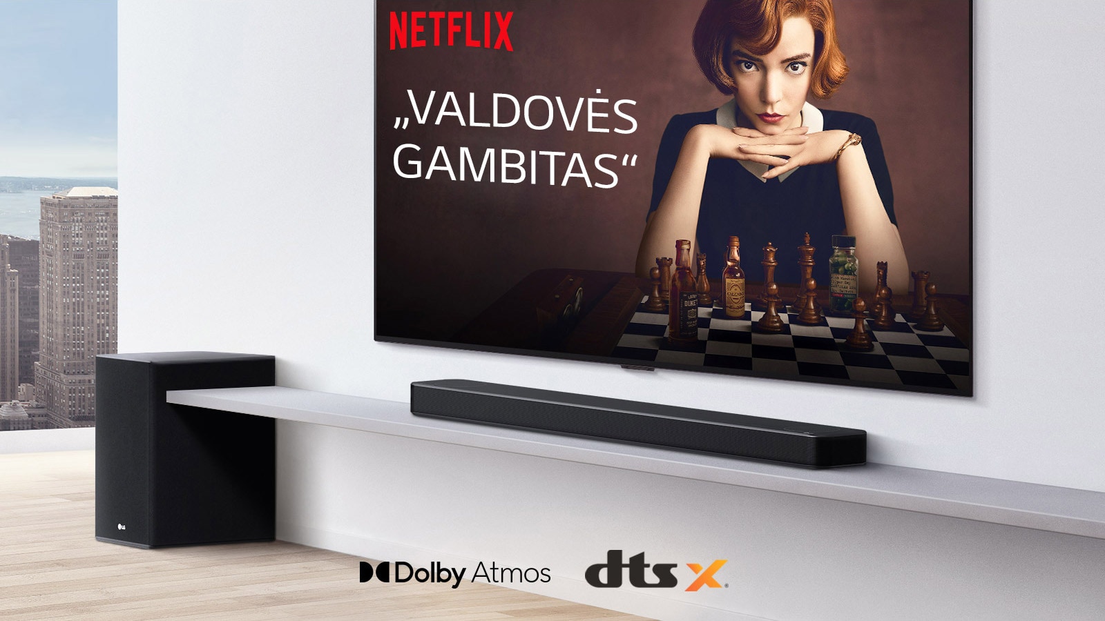 Ant sienos įrengtas televizorius.  Televizoriaus ekrane rodomas TV laidos plakatas. LG Soundbars yra tiesiai po televizoriumi ant baltos lentynos, o šalia yra žemadažnis garsiakalbis. Paveikslėlio apatinėje vidurinėje dalyje yra „Dolby Atmos“ ir DTS:X logotipai.
