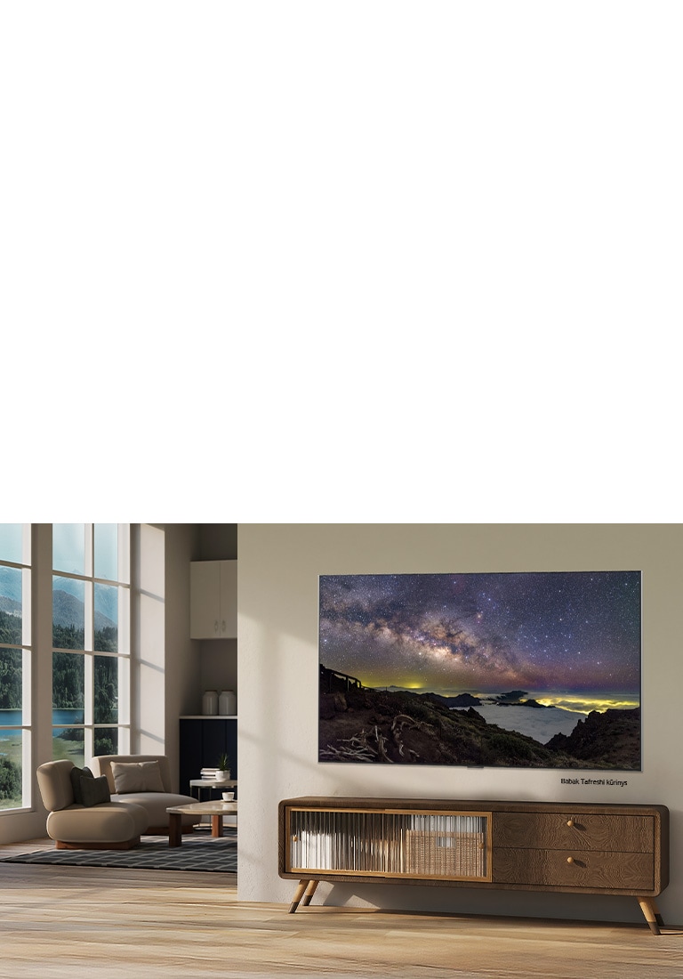 LG NANO 4K UHD AI NU85 su „LG Gallery+“, kuri siūlo įvairų meno turinį, rodo Babako Tafreshio nakties dangaus peizažą modernioje gyvenamojoje erdvėje – tai dalis specialiai atrinktos meno patirties, integruotos į televizoriaus sąsają.