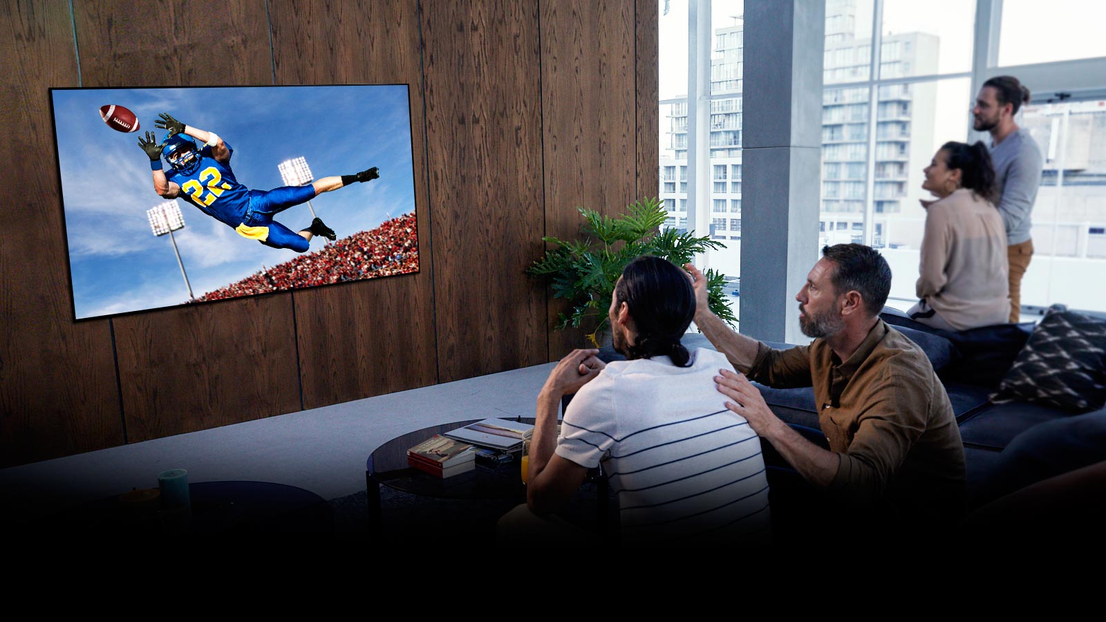 Žmonės svetainėje per TV žiūri žaidimą „Tottenham“