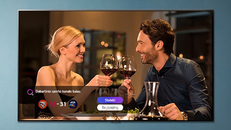 TV ekrane rodomas taurėmis susidaužiantys vyras ir moteris, tuo metu rodomas su sportu susijęs įspėjimas