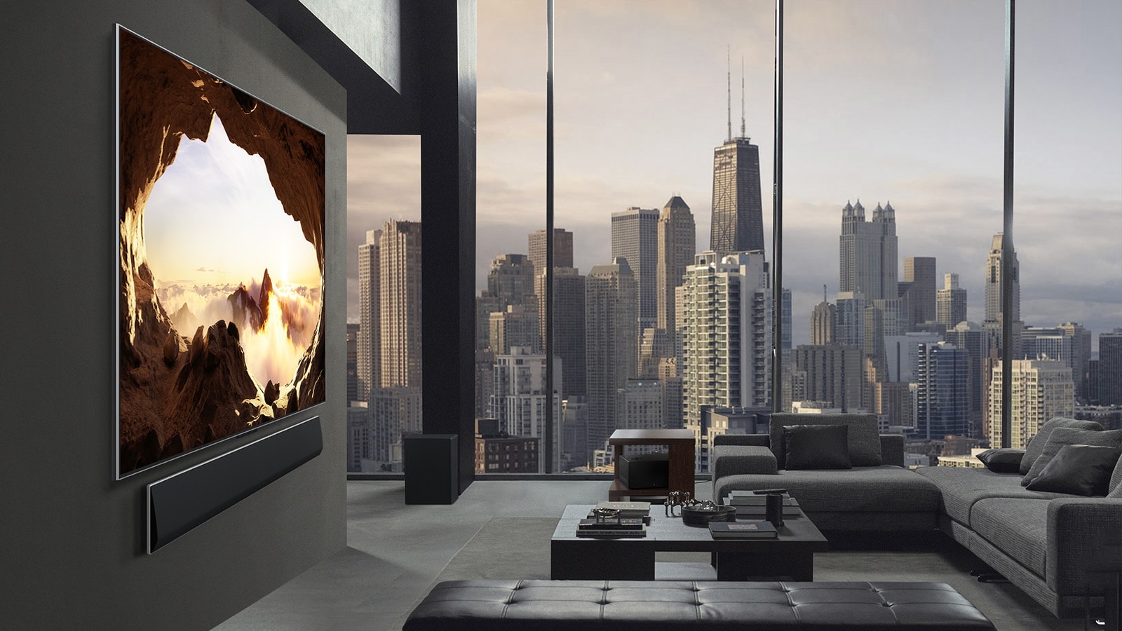 Erdvi svetainė su vaizdu į miesto panoramą. Televizorius „LG OLED TV“ sumontuotas ant sienos su „LG Soundbar“ garso sistema. Dėl televizoriaus dizaino „One Wall Design“ ir itin plonų rėmelių jis puikiai iš šono dera prie sienos ir erdvės. „Zero Connect Box“ yra matoma, bet paslėpta. 