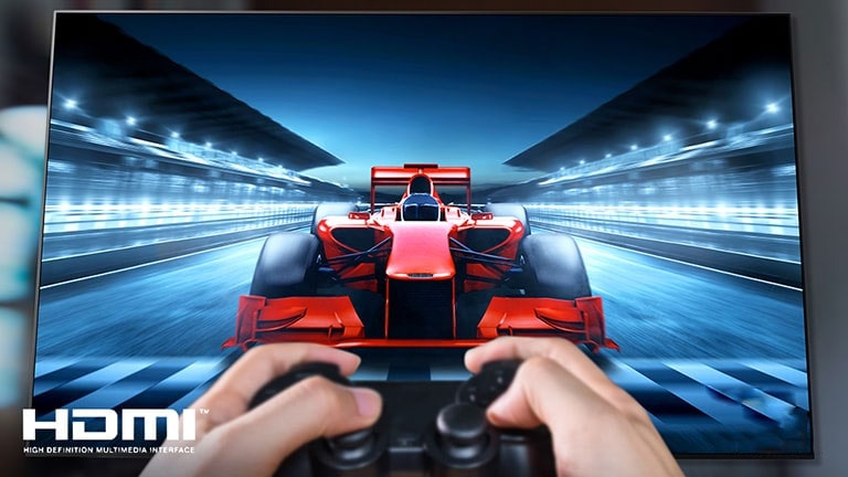 Žaidėjas, televizoriaus ekrane žaidžiantis lenktynių žaidimą, stambiu planu. Vaizdo apačioje kairėje yra HDMI logotipas.