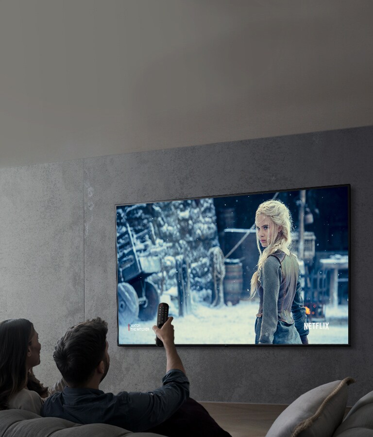 Atvaizdas, kuriame pora žiūri filmą per LG UHD televizorių.