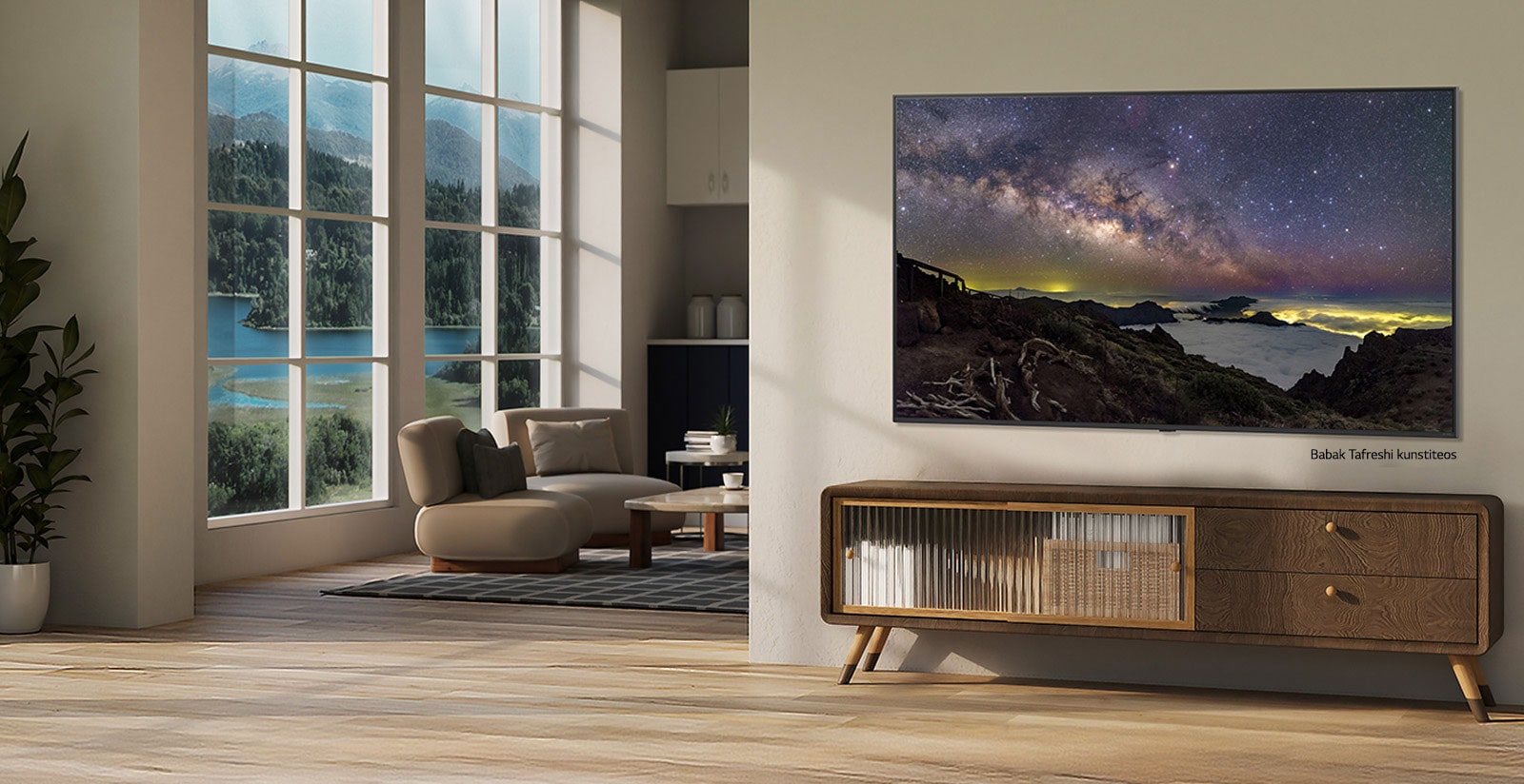 Kaimo vietovės namo interjeras. Didžiulis wall-mounted LG TV ekrane rodo gražų gamtos peizažo meno kūrinį. Televizorius atrodo kaip ant sienos pakabinta nuotrauka. 