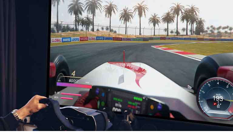 Žaidėjo, laikančio lenktyninio automobilio vairą ir žaidžiančio lenktynių žaidimą TV ekrane, vaizdas stambiu planu.