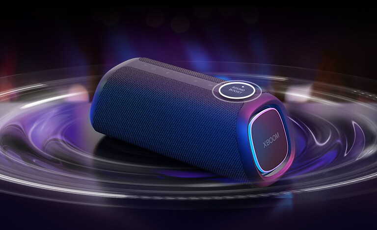 LG XBOOM GO XG7 pastatytas ant stalo. Mygtukas „Sound Boost“ yra padidintas, o garso bangų efektai yra po garsiakalbiu. Paleisti vaizdo įrašą.