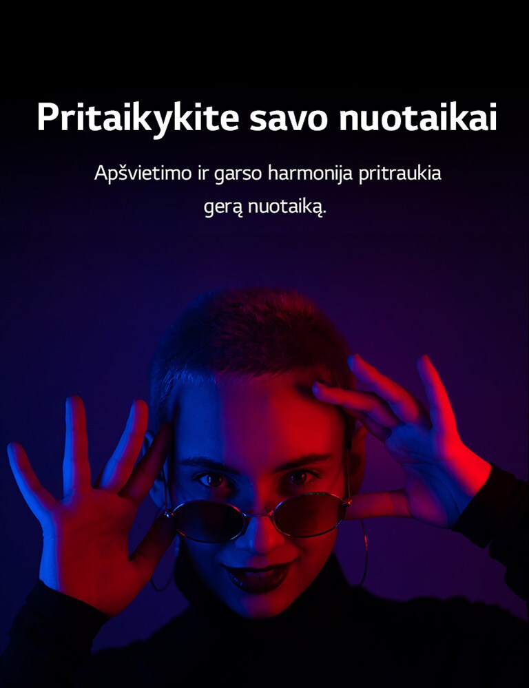 Moteris pozuoja ryškiame apšvietime.