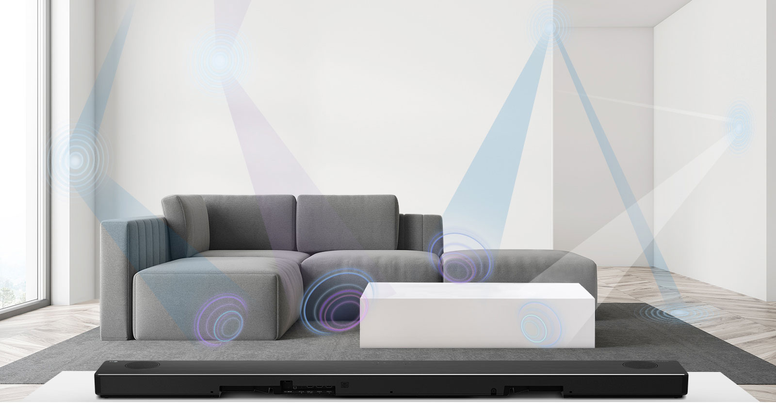 LG horizontaliojo garsiakalbio galinė pusė, įrenginys naudojamas svetainėje, kurios centre stovi pilka sofa. Erdvę matuojančio bangos ilgio grafinis vaizdas.