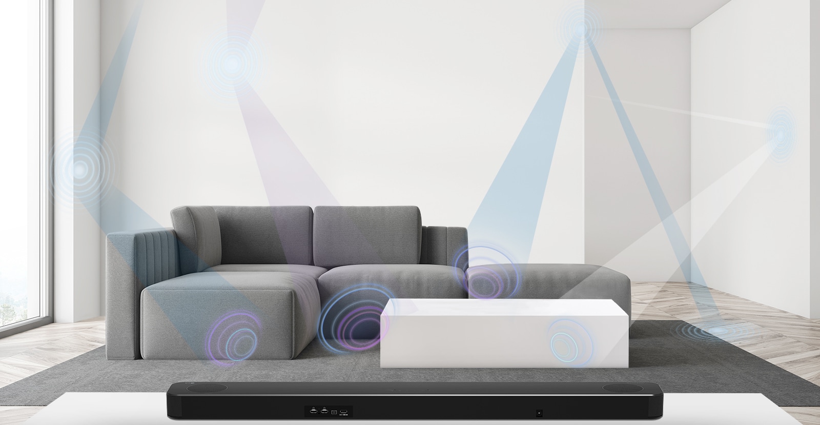 LG horizontaliojo garsiakalbio galinė pusė, įrenginys naudojamas svetainėje, kurios centre stovi pilka sofa. Erdvę matuojančio bangos ilgio grafinis vaizdas.