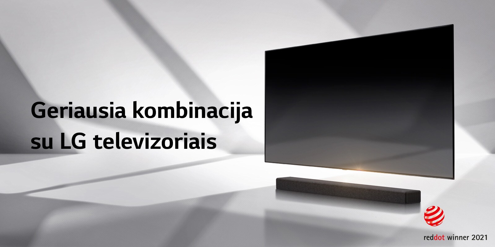 Horizontalusis garsiakalbis ir televizorius pastatyti ant baltų grindų, o už jų krenta šešėlis iš lauko.